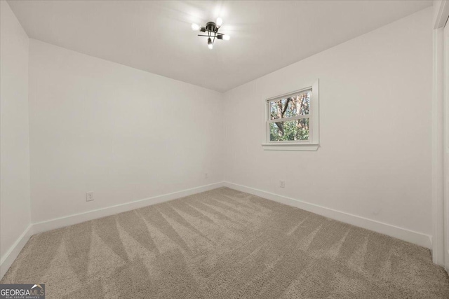 empty room featuring carpet floors and baseboards