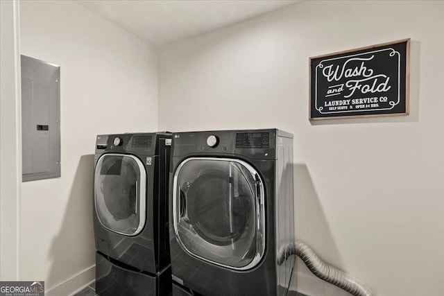 washroom with tile patterned flooring, laundry area, baseboards, washer and dryer, and electric panel