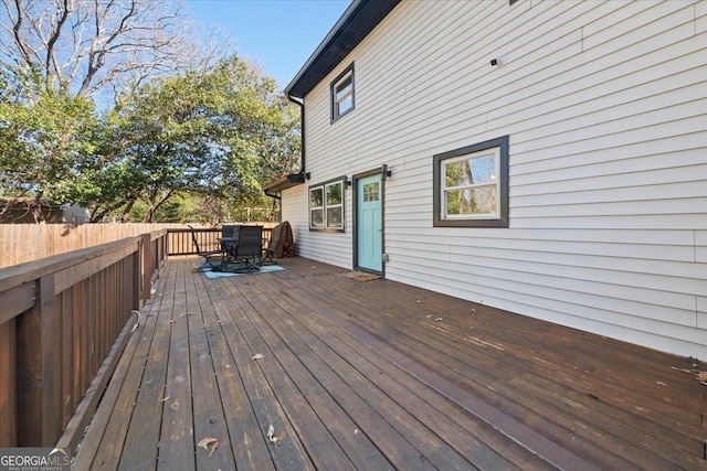 wooden terrace with outdoor dining space and fence