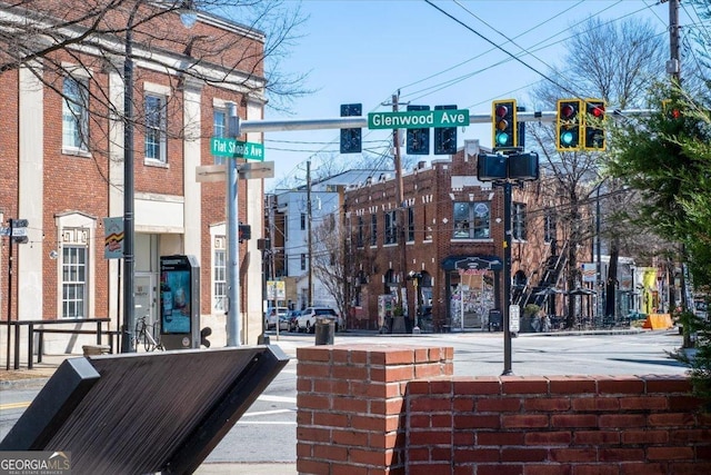 view of street featuring street lights, traffic lights, traffic signs, and sidewalks