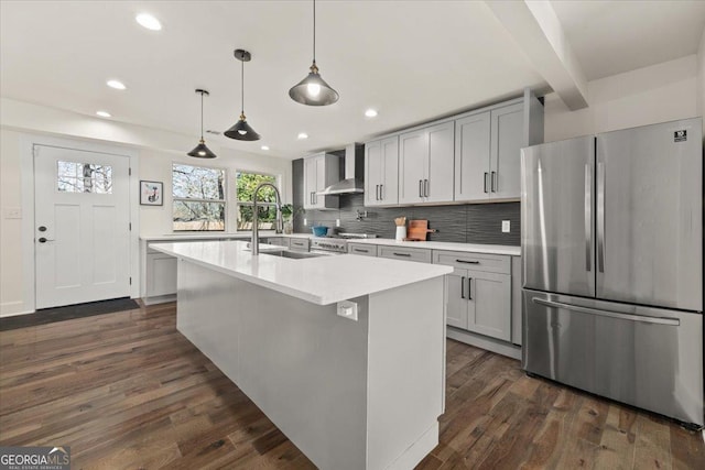 kitchen featuring wall chimney exhaust hood, dark wood finished floors, light countertops, and freestanding refrigerator