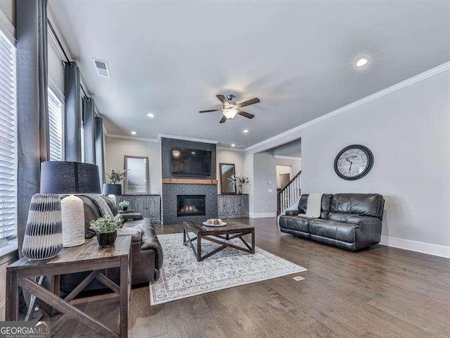 living area with dark wood-style floors, a large fireplace, visible vents, and baseboards