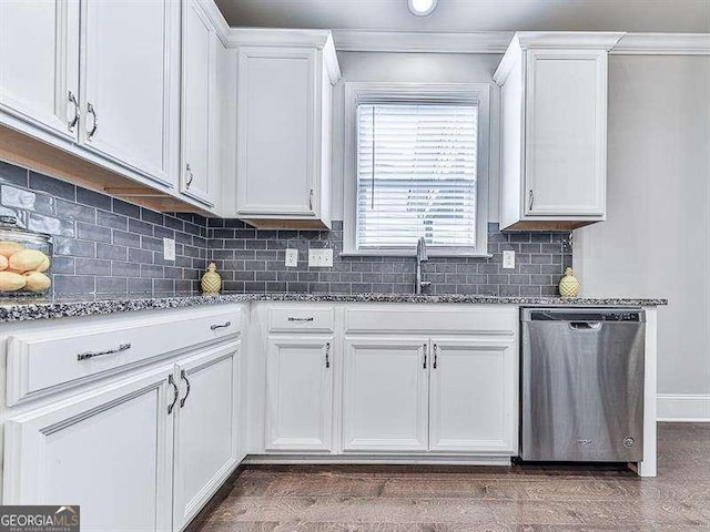 kitchen with a sink, dark stone counters, white cabinets, and dishwasher