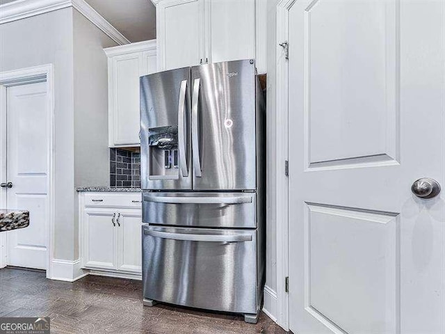 kitchen with stainless steel refrigerator with ice dispenser, tasteful backsplash, stone countertops, dark wood-type flooring, and white cabinets