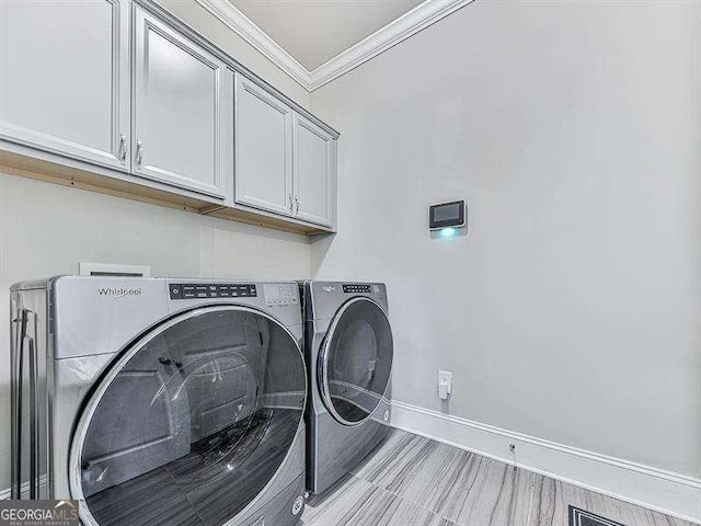 washroom featuring washer and dryer, cabinet space, crown molding, and baseboards