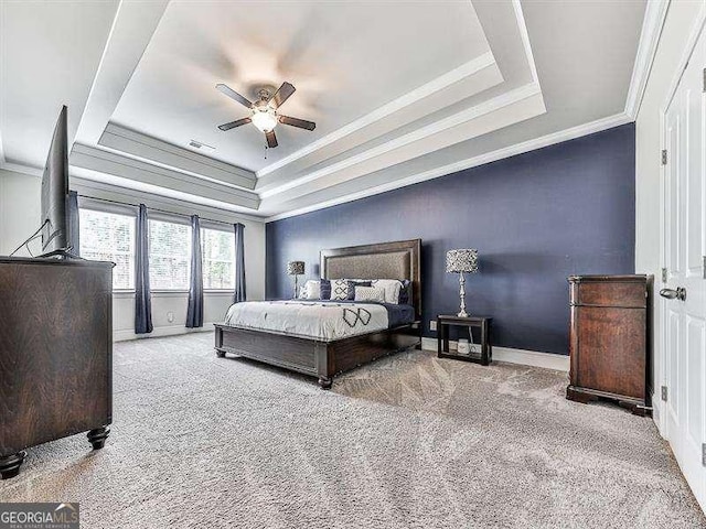 bedroom featuring ornamental molding, a raised ceiling, and light colored carpet