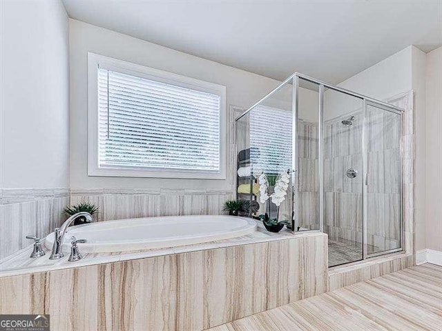 full bathroom featuring a shower stall and a bath