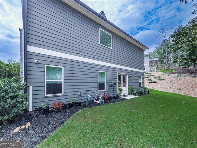 rear view of house featuring a yard