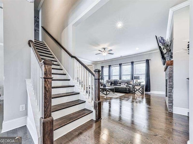 staircase featuring ornamental molding, wood finished floors, a ceiling fan, and baseboards