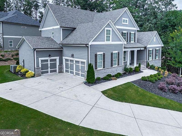 craftsman inspired home featuring a garage, brick siding, driveway, and roof with shingles