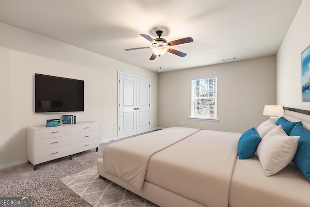 bedroom with a closet, visible vents, a ceiling fan, light carpet, and baseboards