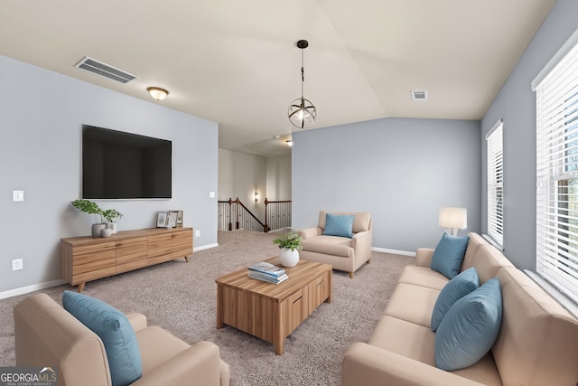 living room featuring vaulted ceiling, carpet, and visible vents