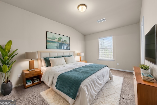 carpeted bedroom featuring lofted ceiling, baseboards, and visible vents