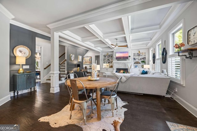 dining space featuring a lit fireplace, stairs, coffered ceiling, and dark wood-type flooring