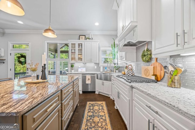 kitchen featuring a center island, stainless steel appliances, glass insert cabinets, white cabinets, and a sink