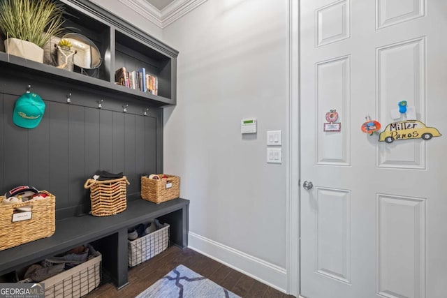 mudroom with dark wood-style floors, ornamental molding, and baseboards