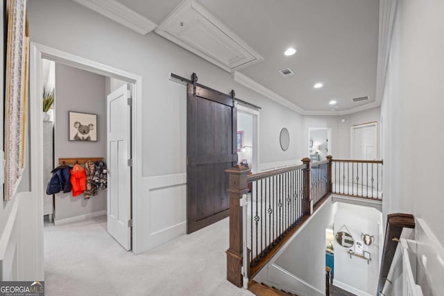 hallway featuring visible vents, light colored carpet, attic access, and crown molding