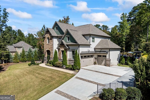 craftsman house with a garage, a shingled roof, concrete driveway, stone siding, and a front yard