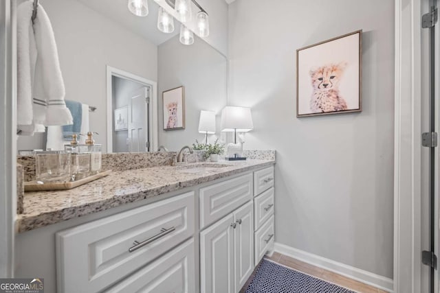 bathroom featuring tile patterned flooring, vanity, and baseboards