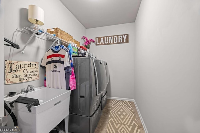 laundry area featuring laundry area, a sink, washer and clothes dryer, and baseboards