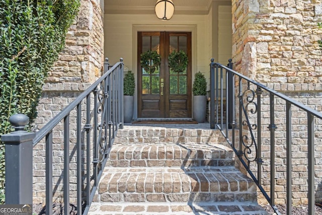 property entrance featuring stone siding and french doors