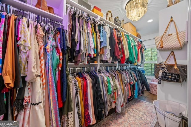 walk in closet featuring a chandelier and wood finished floors