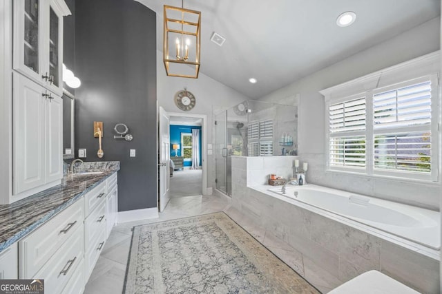 bathroom with lofted ceiling, ensuite bath, a garden tub, vanity, and a shower stall