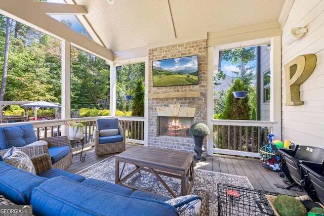 sunroom / solarium featuring lofted ceiling with beams and an outdoor brick fireplace