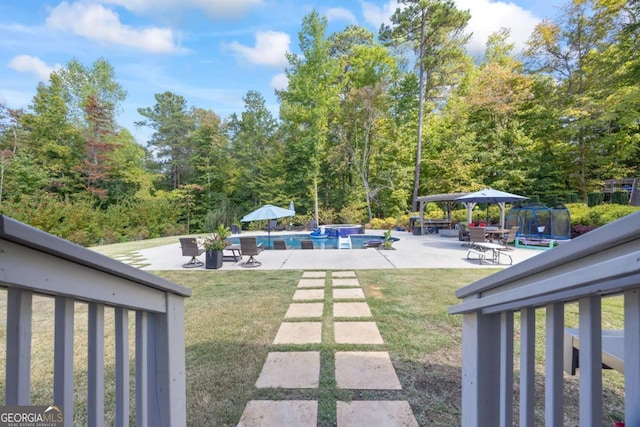 view of yard with a gazebo, a trampoline, a patio area, and an outdoor pool