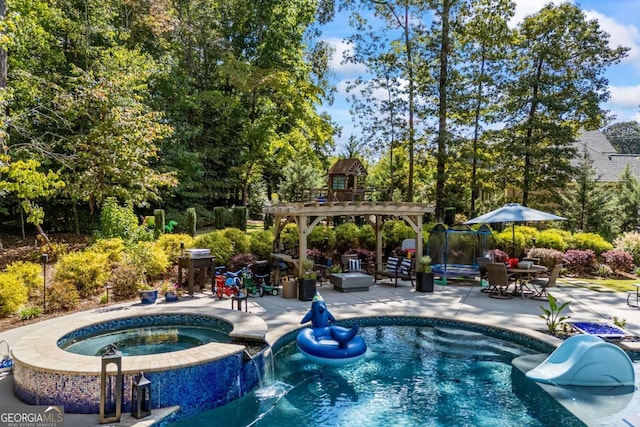 view of swimming pool featuring a pool with connected hot tub, a pergola, and a patio