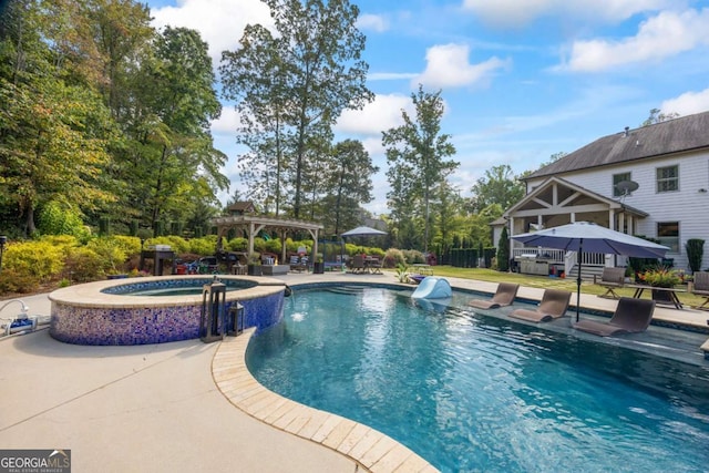 view of swimming pool featuring a pool with connected hot tub, a patio, and a pergola