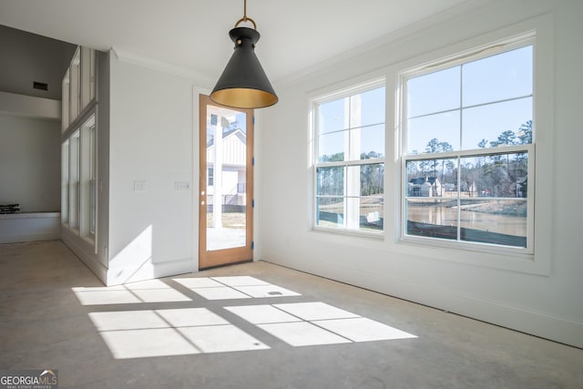 interior space featuring ornamental molding, concrete flooring, and baseboards