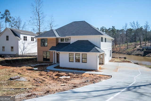 modern inspired farmhouse featuring a shingled roof and board and batten siding