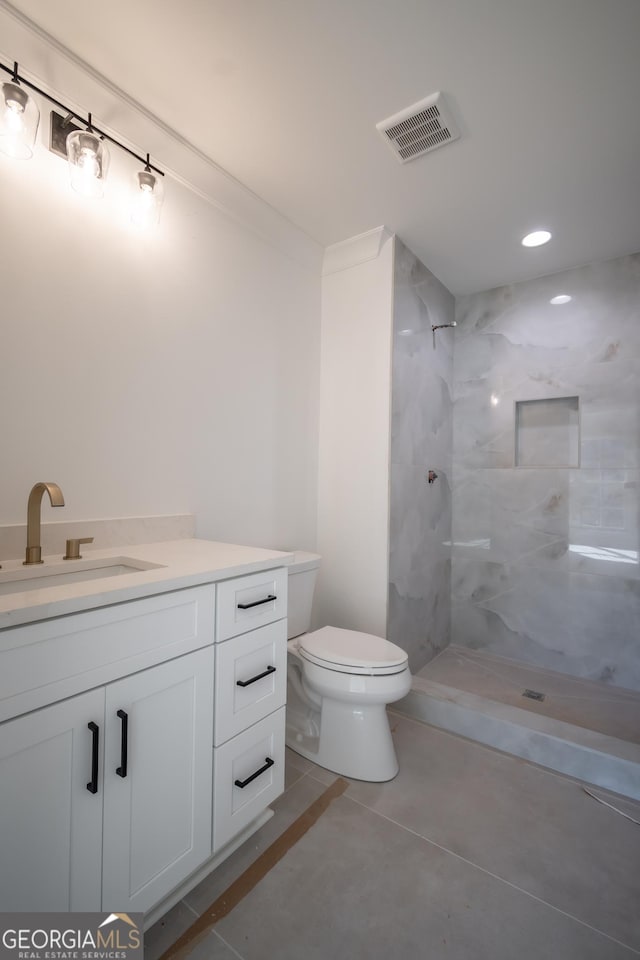 bathroom featuring a stall shower, visible vents, toilet, tile patterned flooring, and vanity