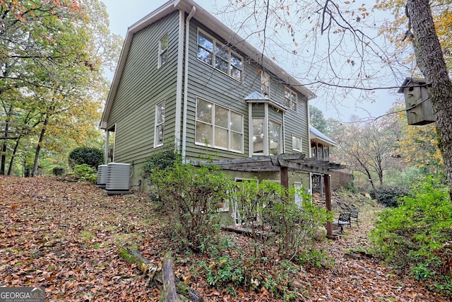 view of side of property featuring central AC unit and a pergola