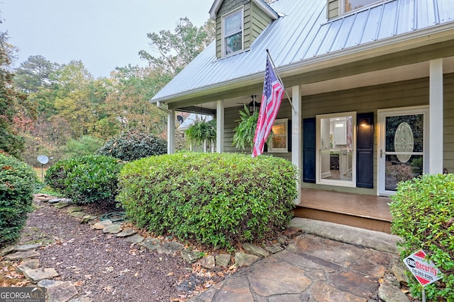 doorway to property featuring covered porch and metal roof