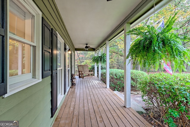 wooden terrace featuring covered porch and ceiling fan