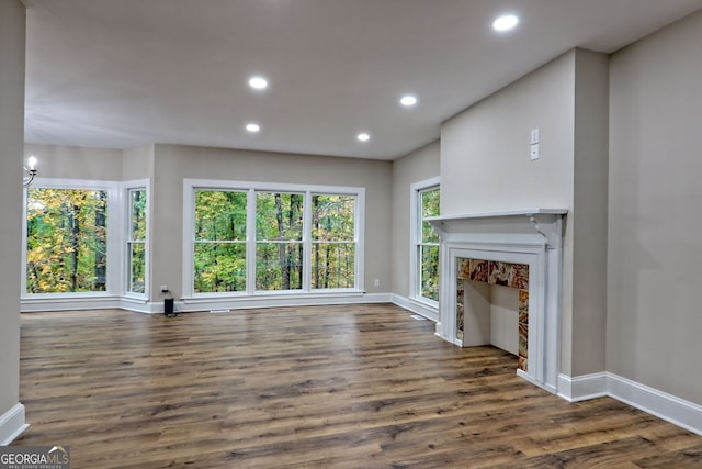 unfurnished living room featuring dark wood-style floors, a fireplace, baseboards, and recessed lighting