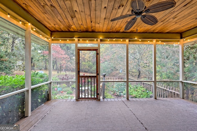 unfurnished sunroom featuring wooden ceiling and ceiling fan