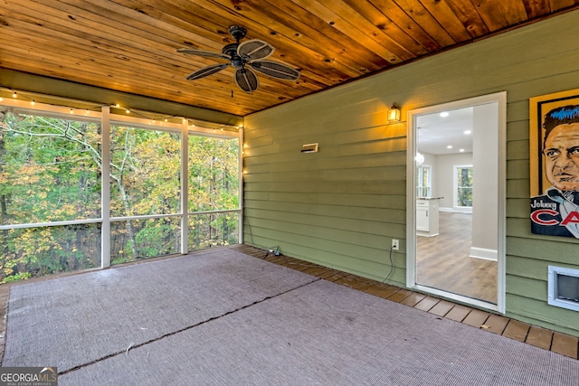 unfurnished sunroom with a ceiling fan and wooden ceiling