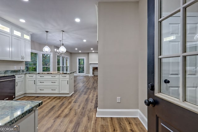 kitchen with black dishwasher, glass insert cabinets, white cabinets, and decorative light fixtures