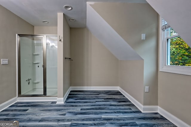 bathroom featuring a stall shower, wood finished floors, and baseboards