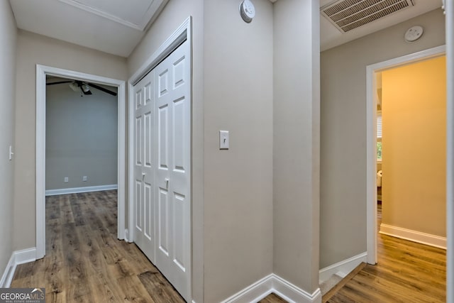 corridor with visible vents, baseboards, and wood finished floors