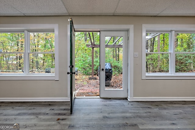 entryway featuring a paneled ceiling, baseboards, and wood finished floors