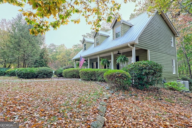 view of side of property featuring metal roof, covered porch, and ceiling fan