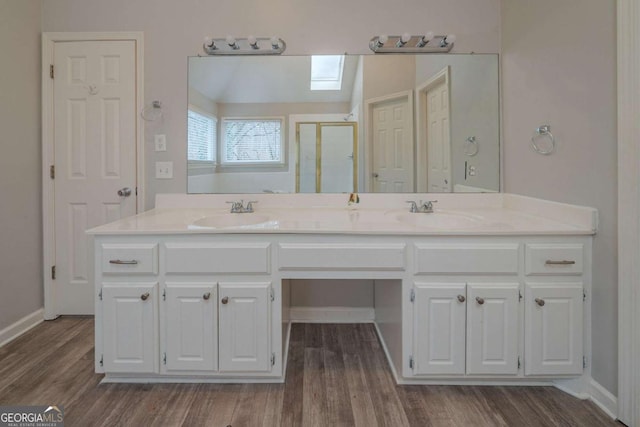 4570 Thicket Trl, Snellville, GA 30039 - bathroom featuring a stall shower, double vanity, and wood finished floors