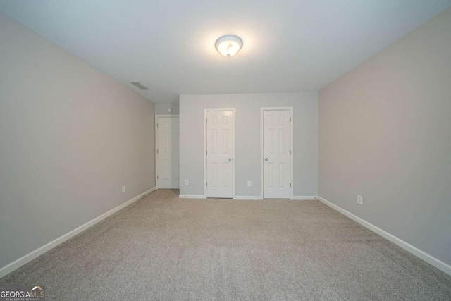 4570 Thicket Trl, Snellville, GA 30039 - unfurnished bedroom featuring multiple closets and light colored carpet