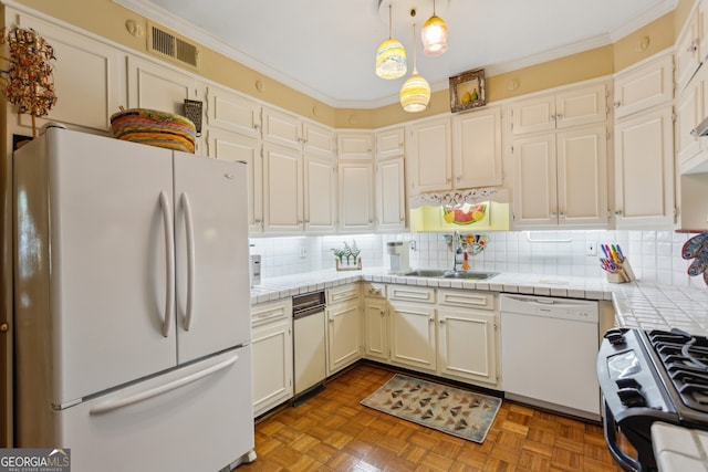 kitchen featuring white appliances, decorative backsplash, visible vents, and pendant lighting