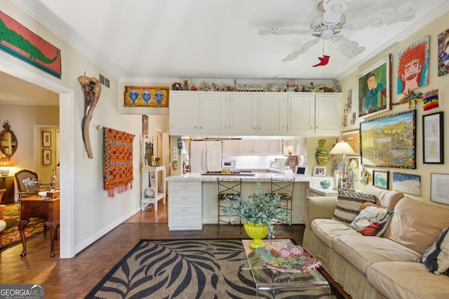 living area featuring ceiling fan, ornamental molding, visible vents, and baseboards