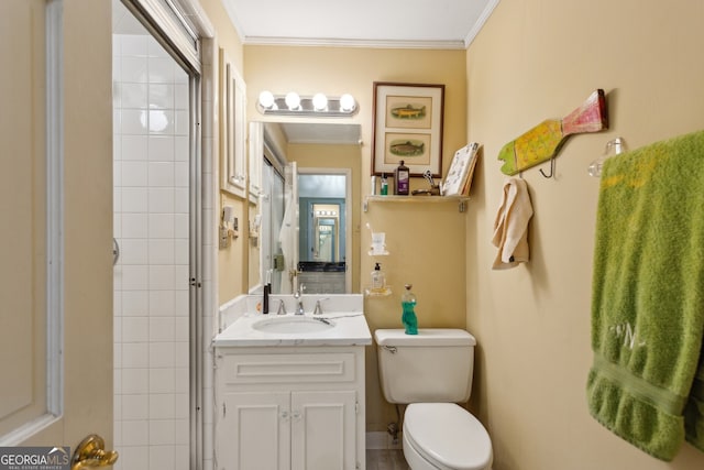 bathroom featuring vanity, ornamental molding, a tile shower, and toilet